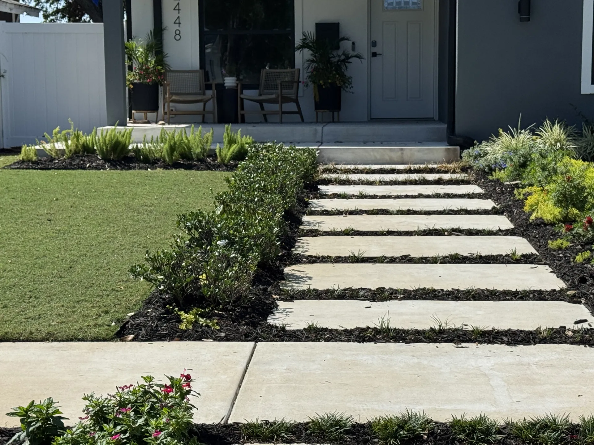 Concrete stepping stone walkway leading to the front door of a modern home