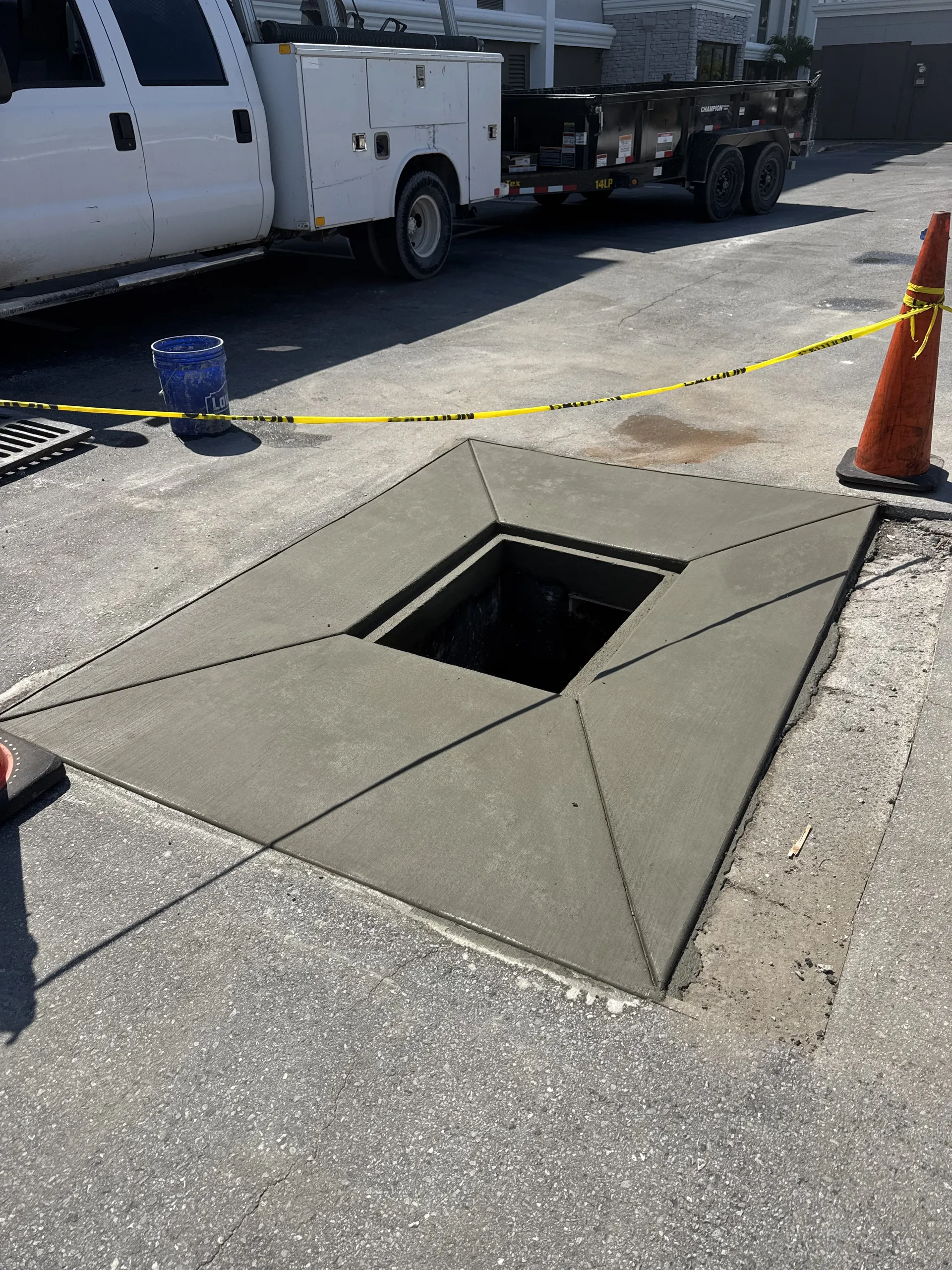 Freshly poured concrete utility pad with bollards and water valve