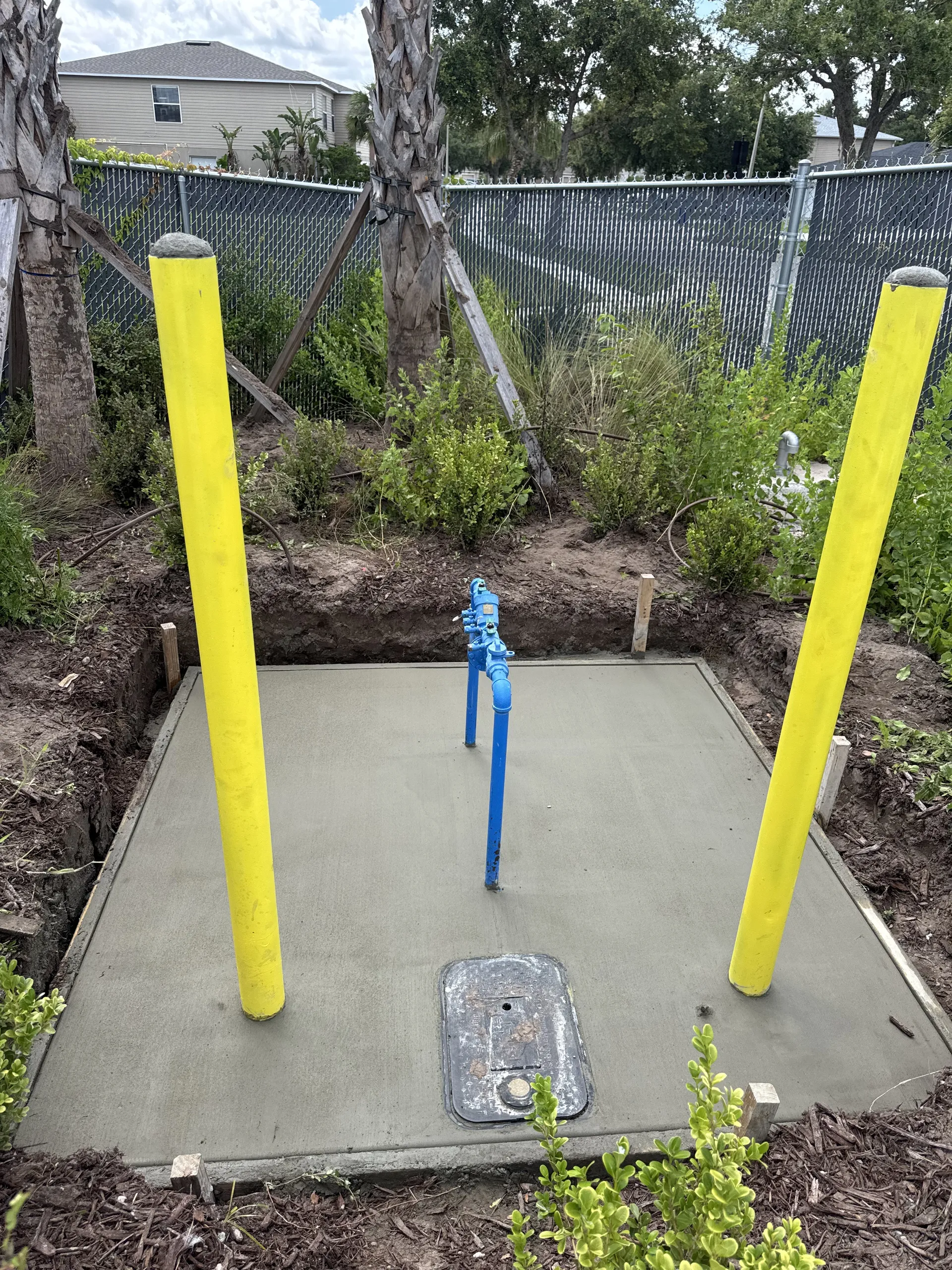 Concrete utility equipment pad with safety bollards