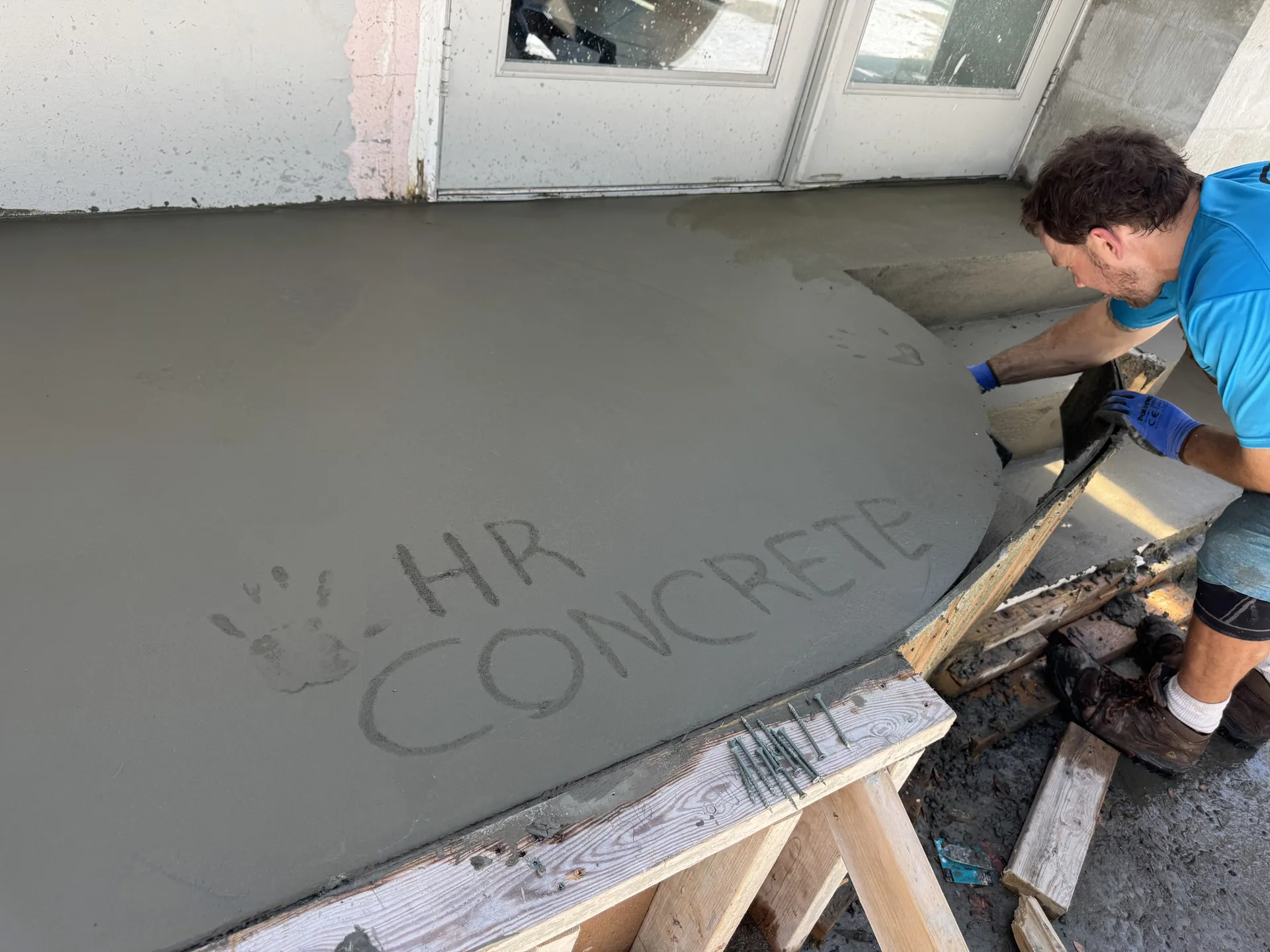 HR Concrete Services worker finishing a concrete balcony repair