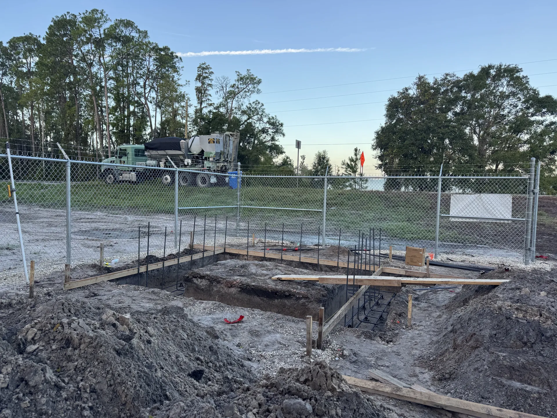 Concrete foundation footers with rebar and wooden forms at a construction site