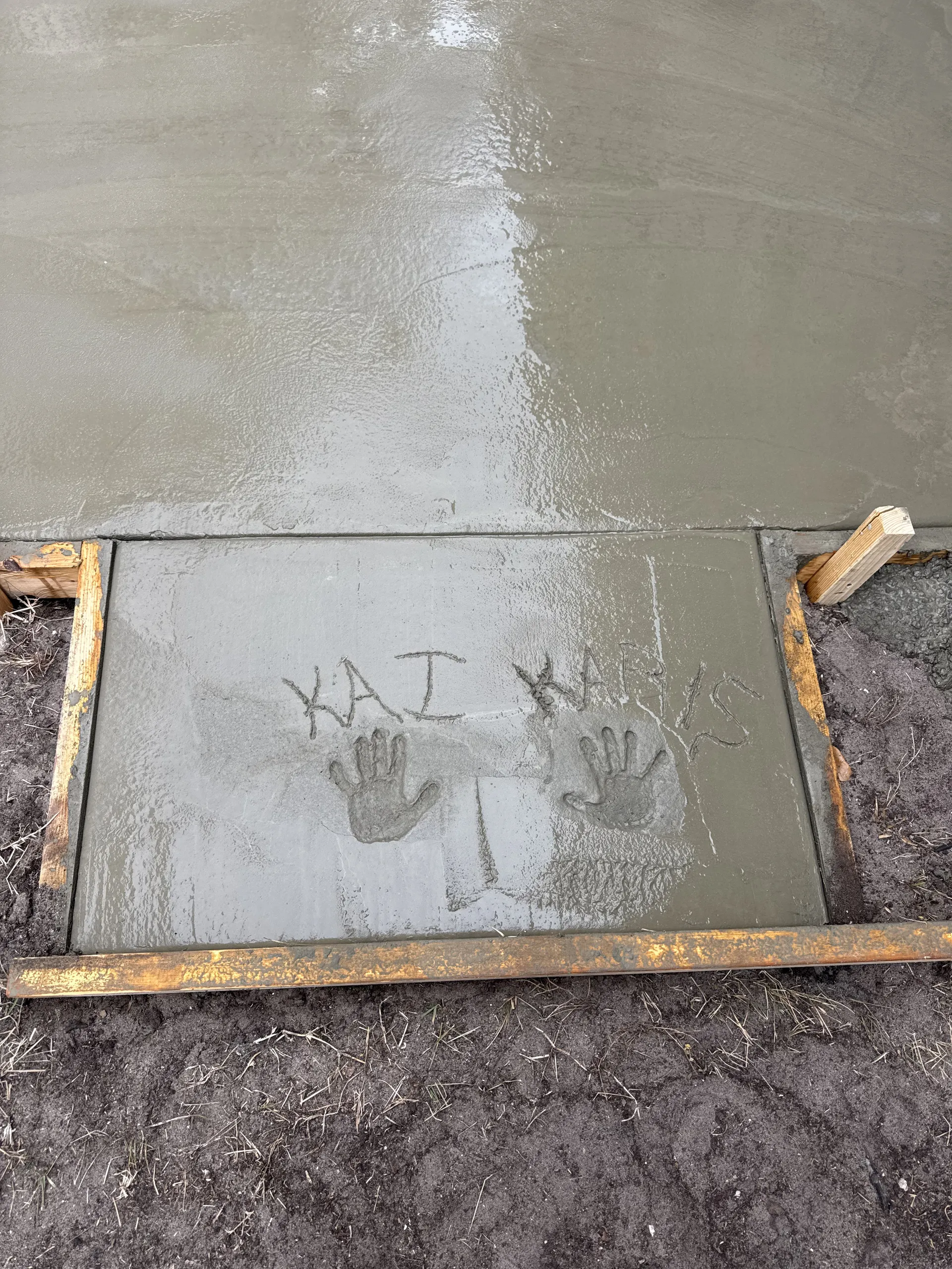 Children's handprints pressed into freshly poured concrete