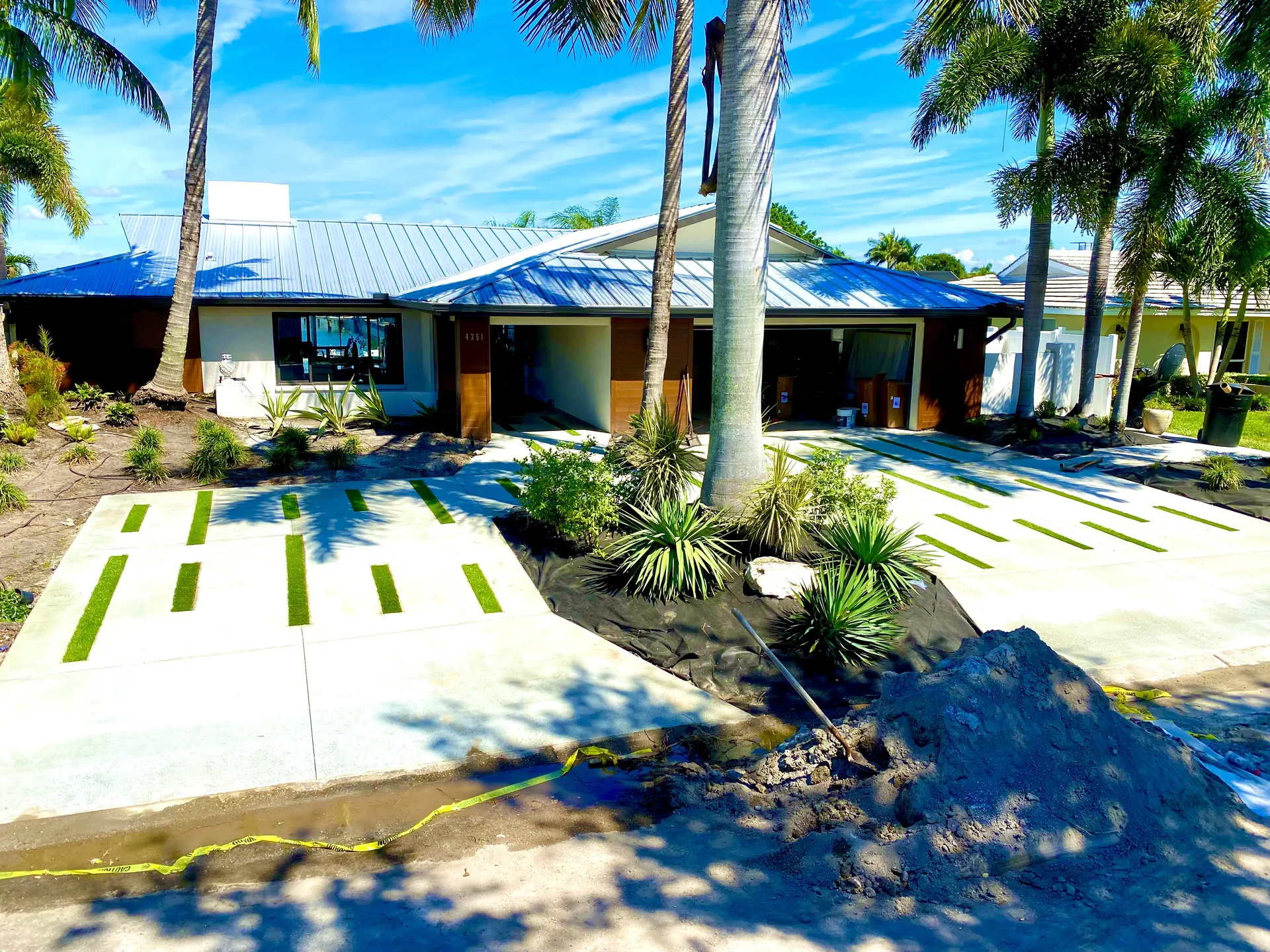 Modern ribbon concrete driveway with turf strips at a Florida home